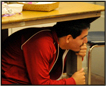 Boy under the table during an earthquake 